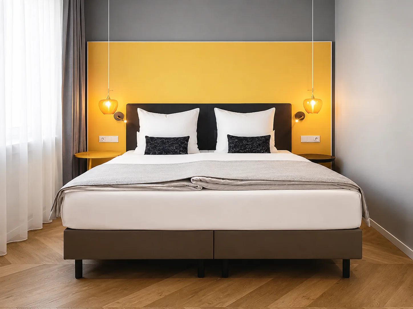 Doppelbett mit gelbem Kopfteil im HIAMO Hotel