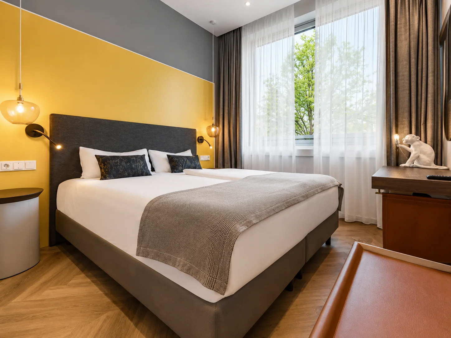 Cozy Zimmer mit Doppelbett und gelbem Kopfteil im HIAMO Hotel