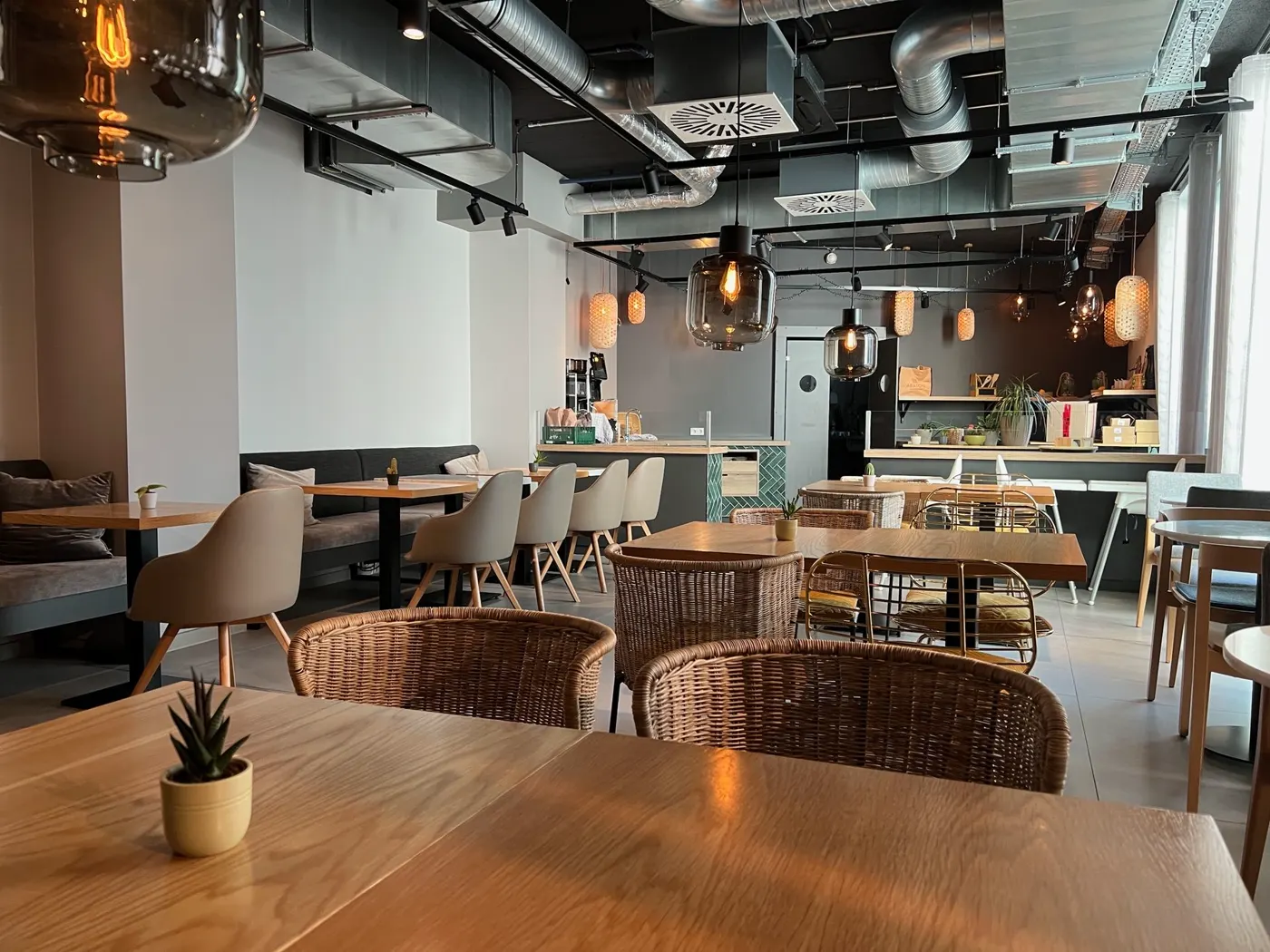 Frühstücksraum des HIAMO Hotels mit Holztischen und Korbstühlen